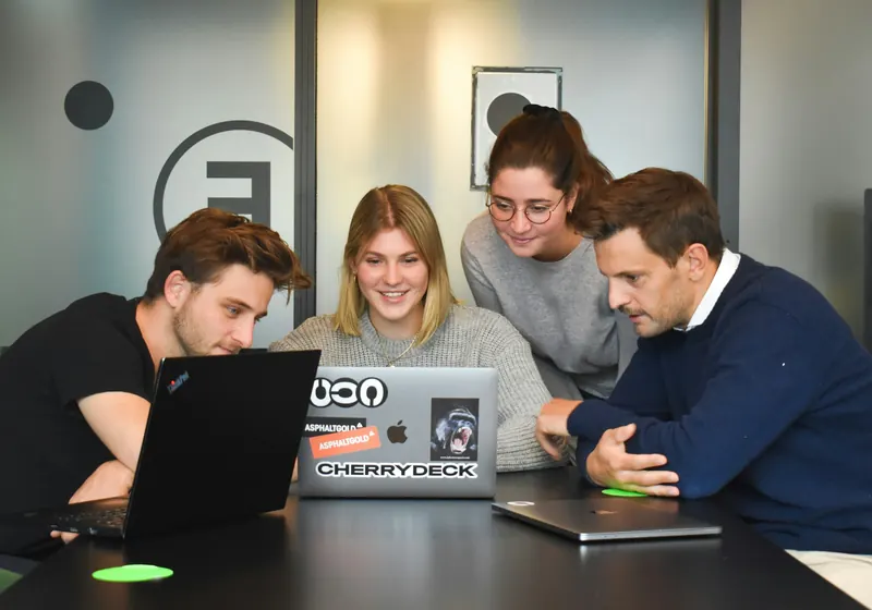 A small team working together around a laptop